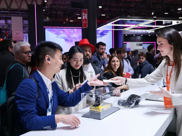 Azafata de Xiaomi entregando documentación a un visitante en el stand